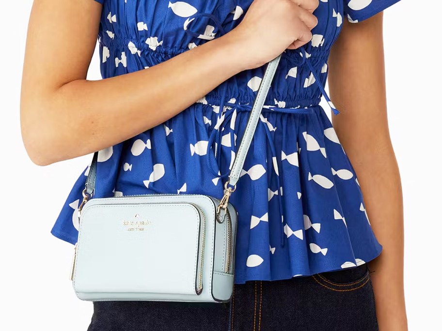 woman in a blue and white top with a light blue crossbody bag