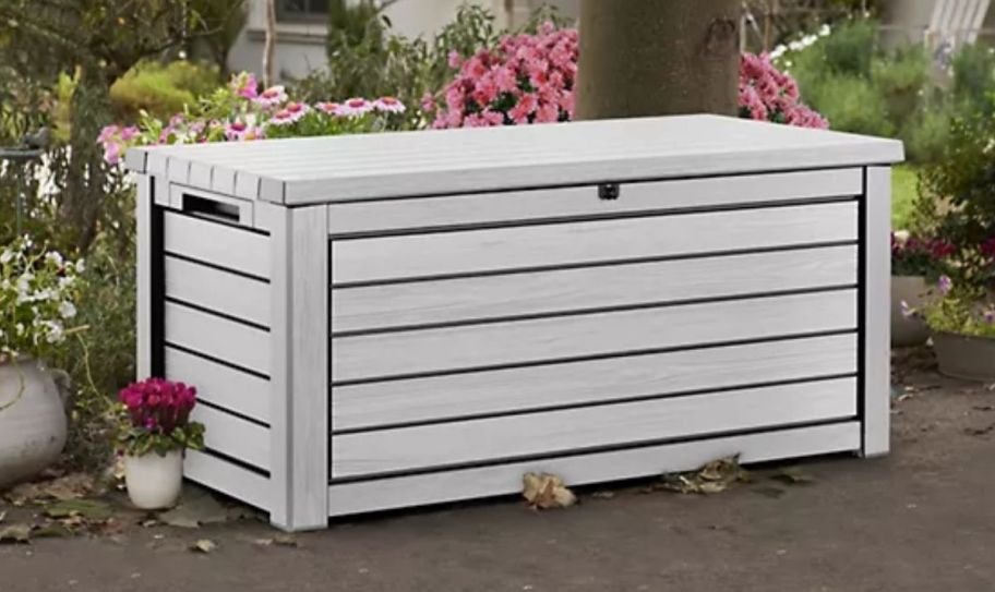 a 165 gallon white deck box, in a backyard