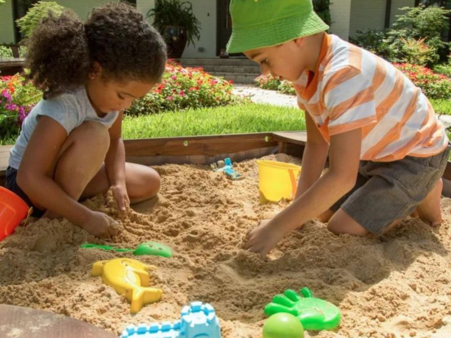 2 kids playing in a sandbox