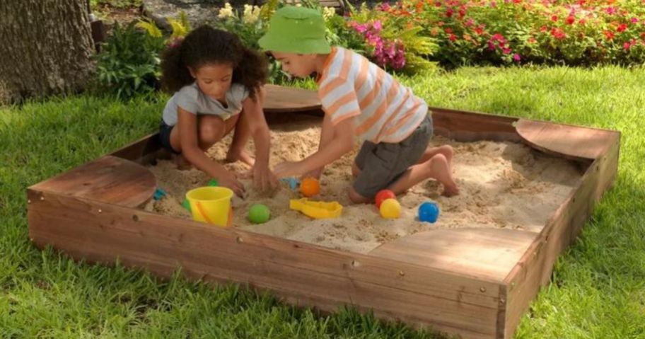 2 kids playing in a Kidkraft sandbox