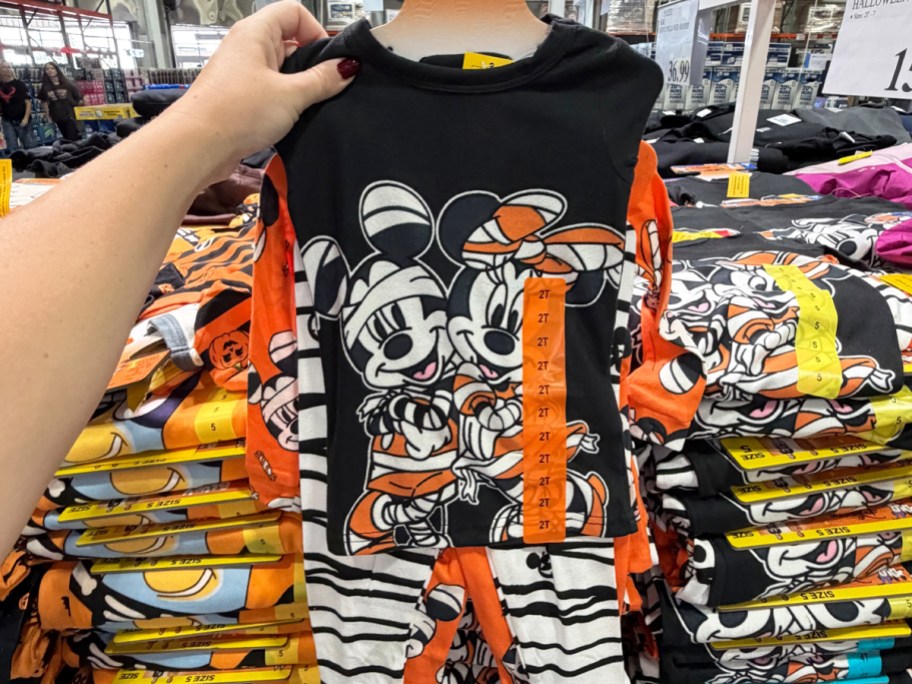 hand holding up disney halloween pajamas in store