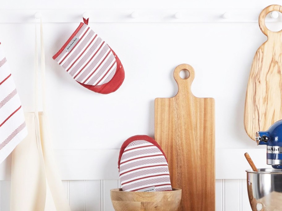 red and white striped pot holders hanging from hook and in wooden mixing bowl in kitchen