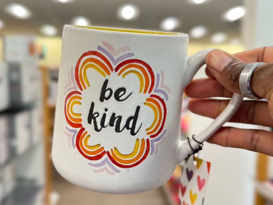 Hand holding up a Be Kind Coffee Mug from Kohl's