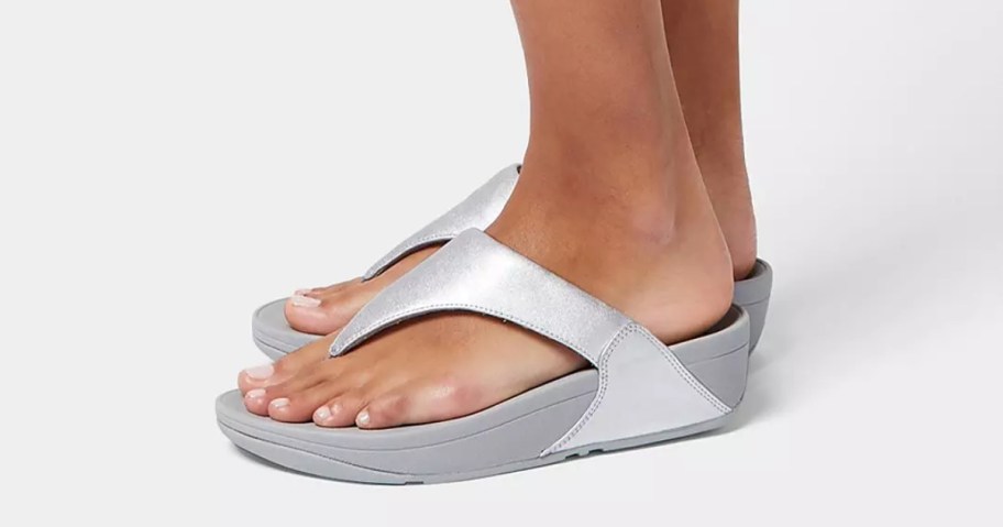 woman wearing silver flip flops
