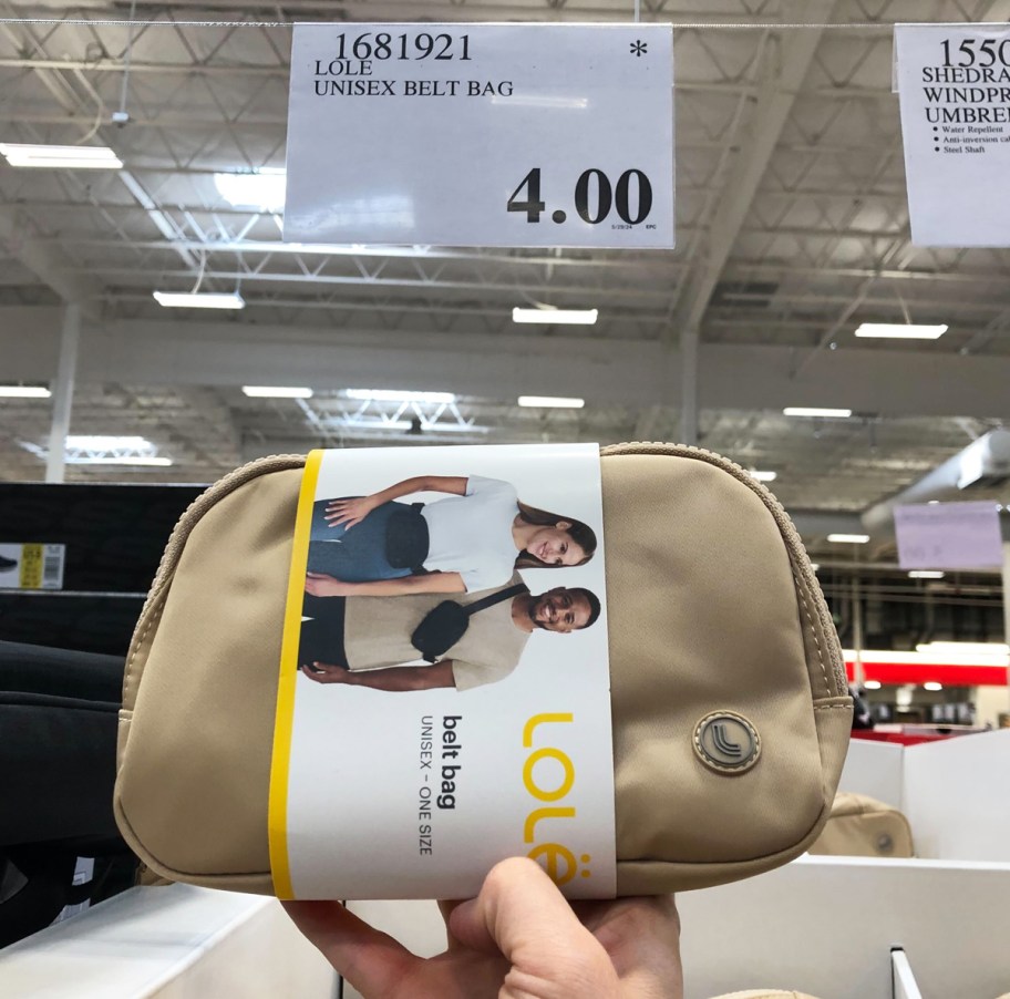 hand holding up a tan belt bag in front of $4 price tag