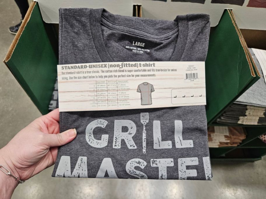 A hand holding a Lowes T-Shirt that says Grill Master