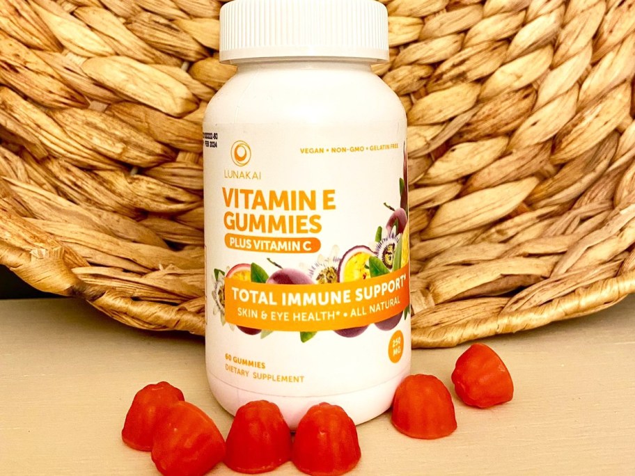 bottle of Lunakai Vitamin E Gummies with red gummies in front of it