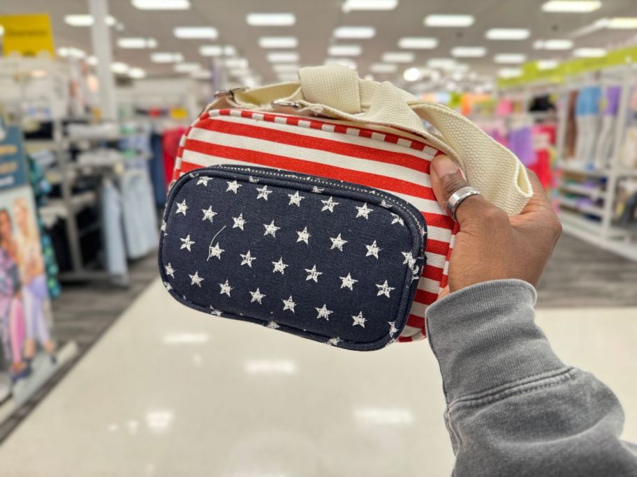 A hand holding a Mad Love Americana Camera Crossbody Bag in Target