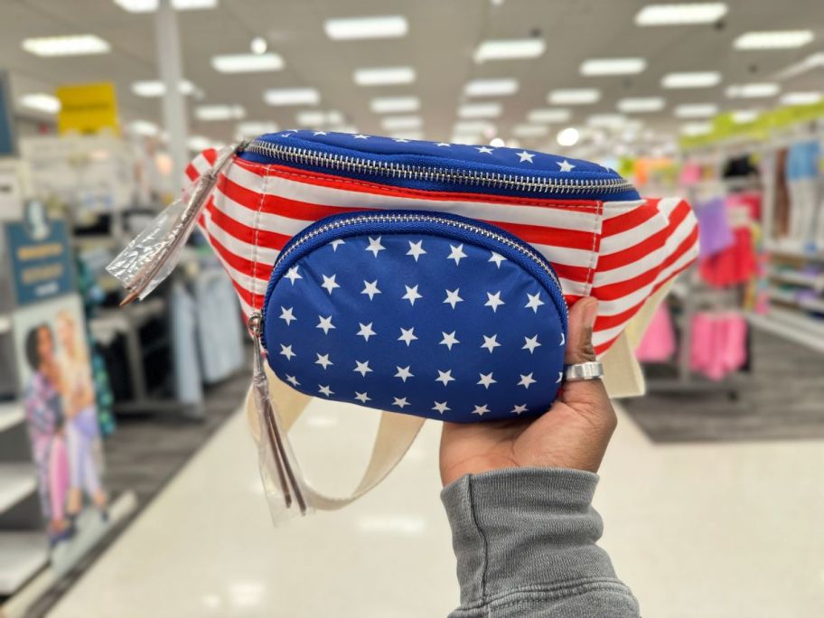 A hand holding a Mad Love Americana Belt Crossbody Bag at Target