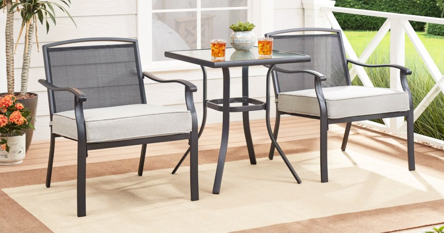 Two patio chairs with gray cushions and side table