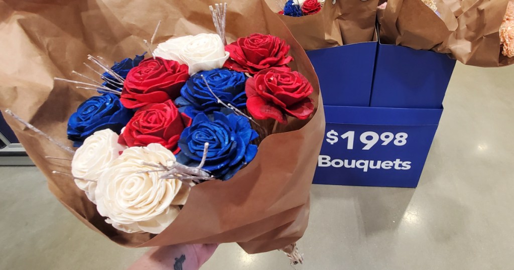 woman holding up red white blue flowers in lowes