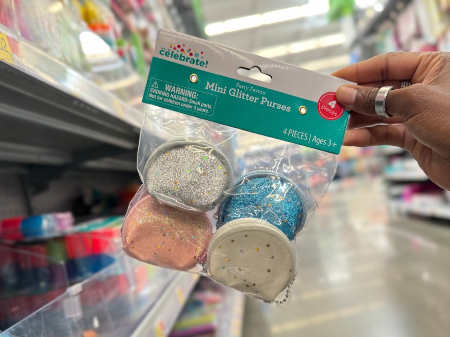 person holding up bag of Mini Glitter Purses in Walmart store