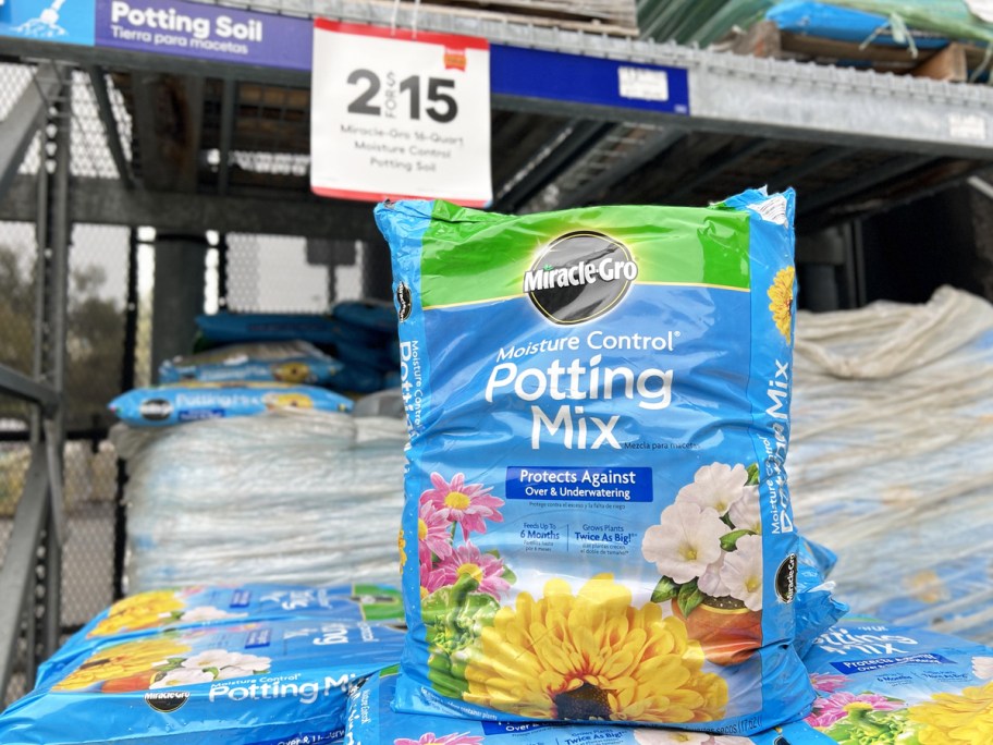 blue bag of Miracle-Gro Potting Soil near 2/$15 sale sign
