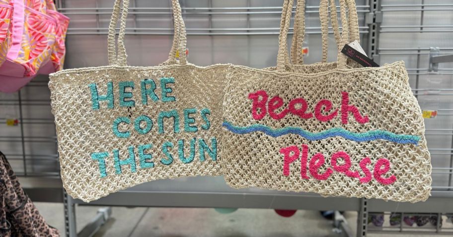 two no boundaries beach totes hanging on rack in store