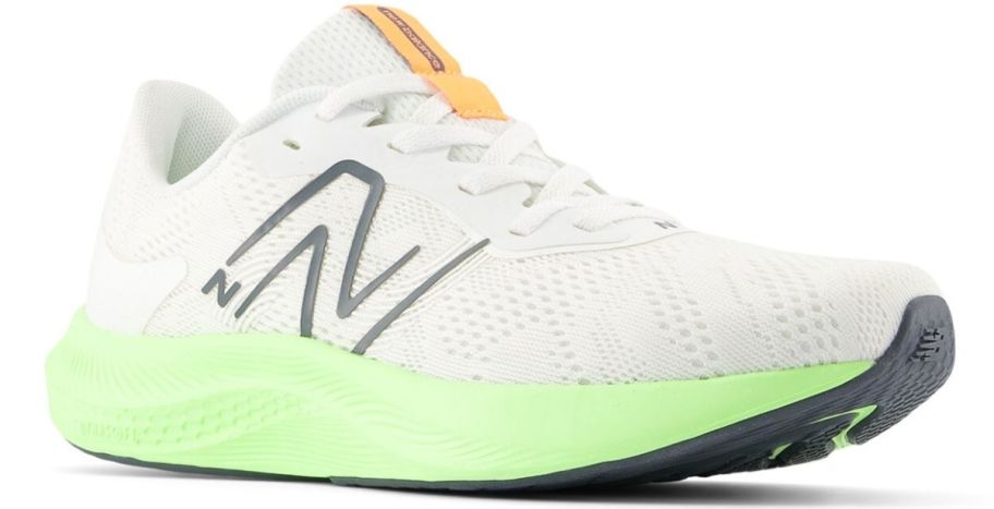a womans white new balance sneaker with lime green sole