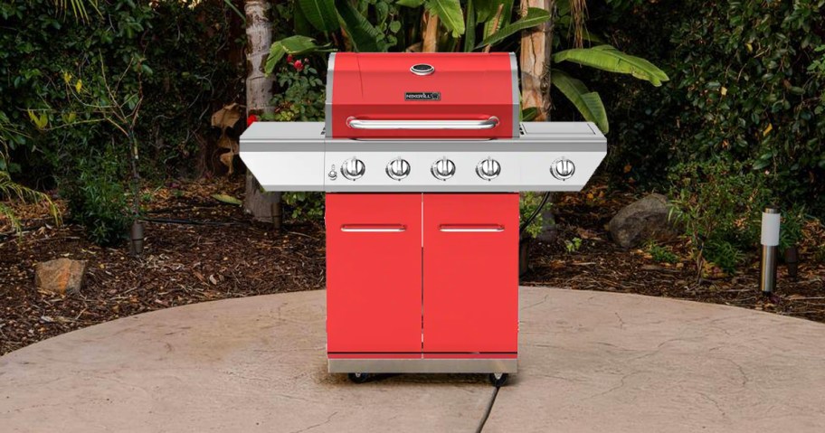 red and silver gas grill in backyard