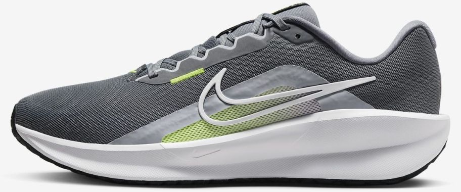 a gray and white mens running shoe with neon green accents