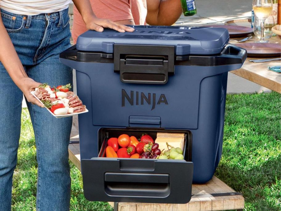 Woman using a Ninja Frostvault cooler