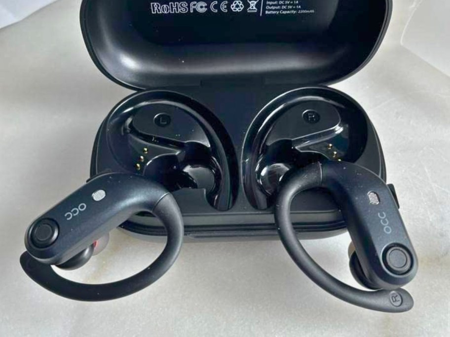 pair of black wireless over the ear headphone earbuds in a charging case