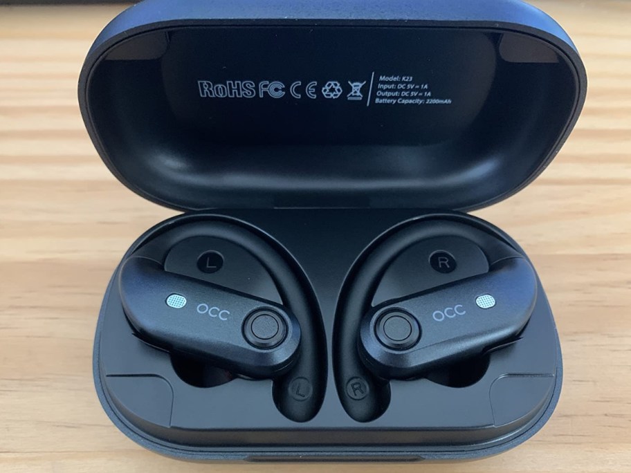pair of black wireless over the ear headphone earbuds in a charging case