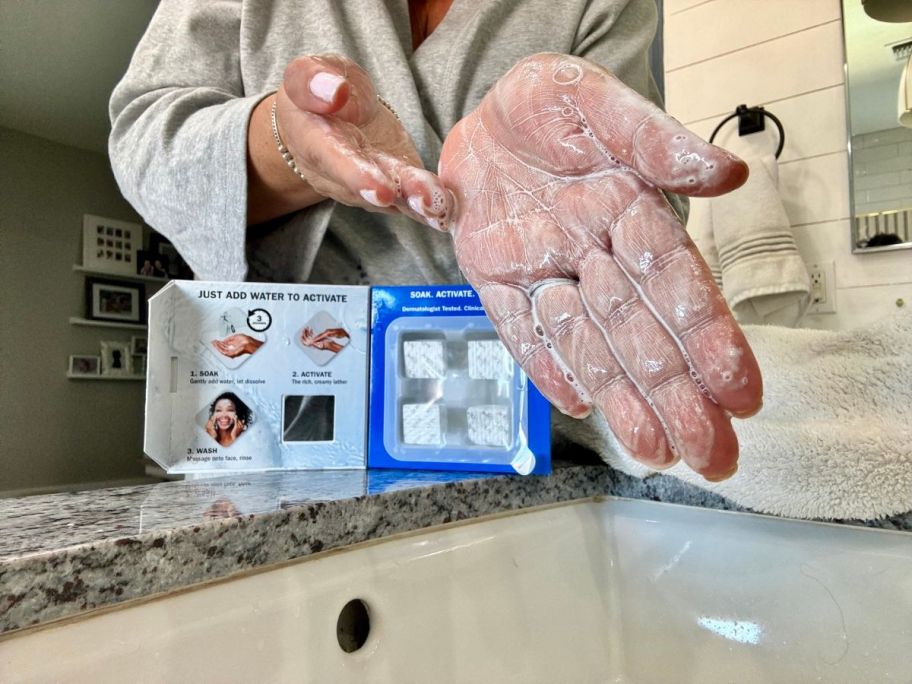 A woman washing her hands with Olay Cleansing Melts