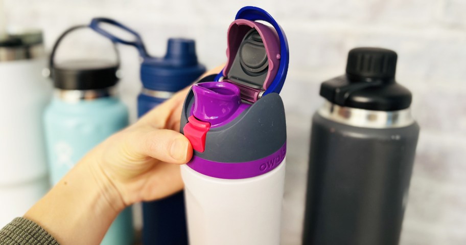 hand holding a purple water bottle showing the inside of drinking cap