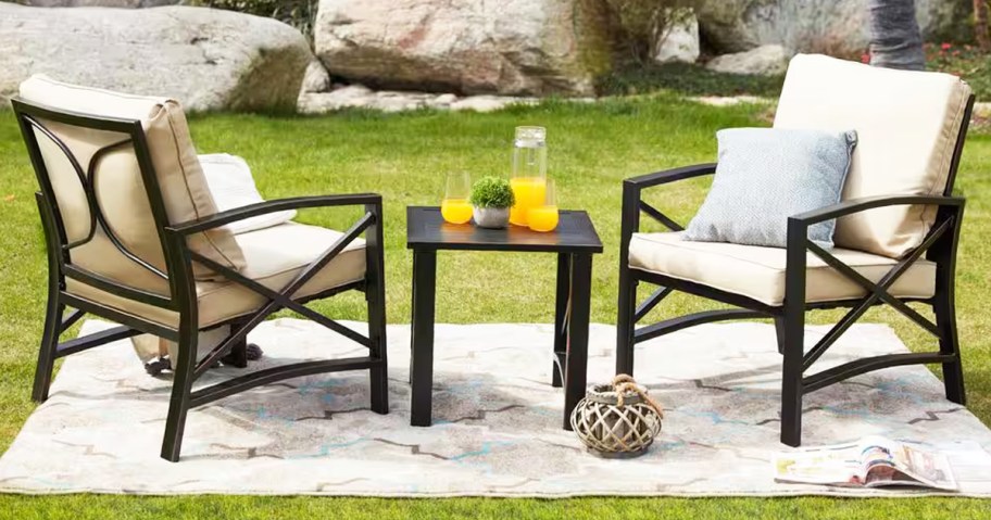 patio chairs with beige cushions and matching side table on grass