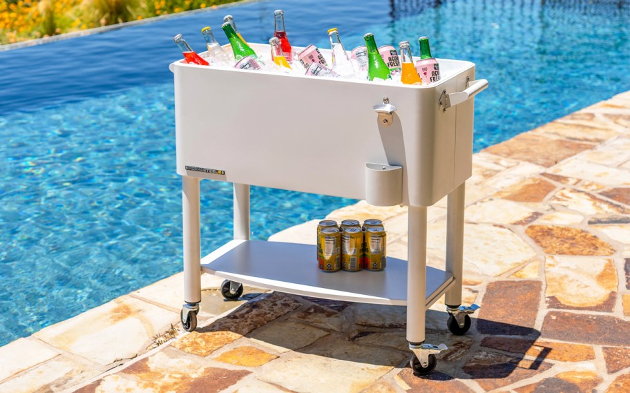 white beverage cooler on wheels near a pool