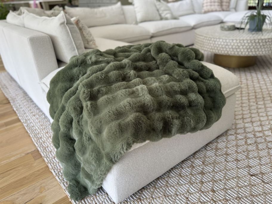 A couch with Quince faux fur blanket draped on it