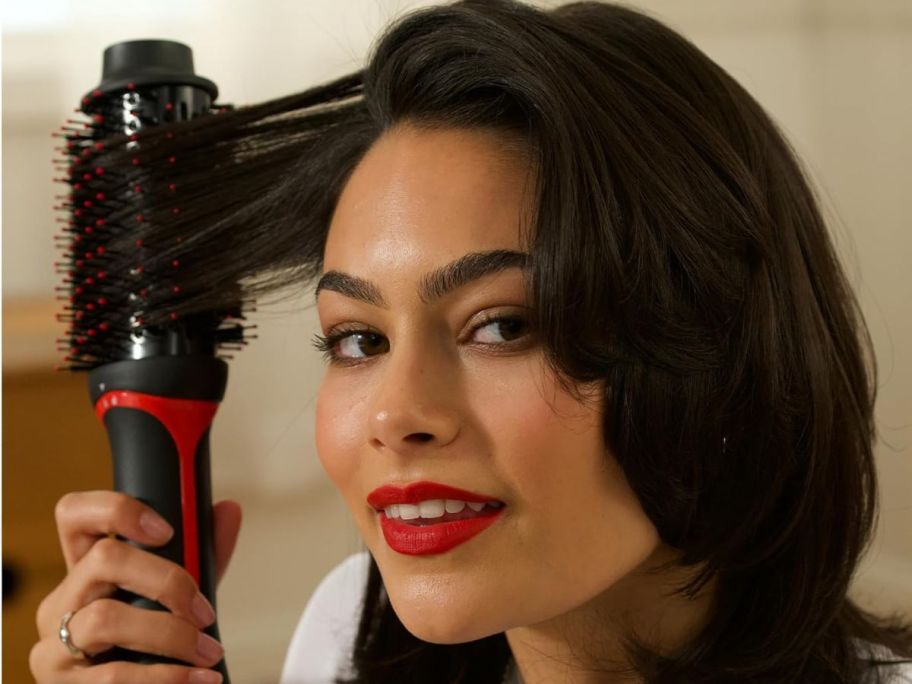 A woman with a REVLON One Step Volumizer PLUS Hair Dryer and Styler