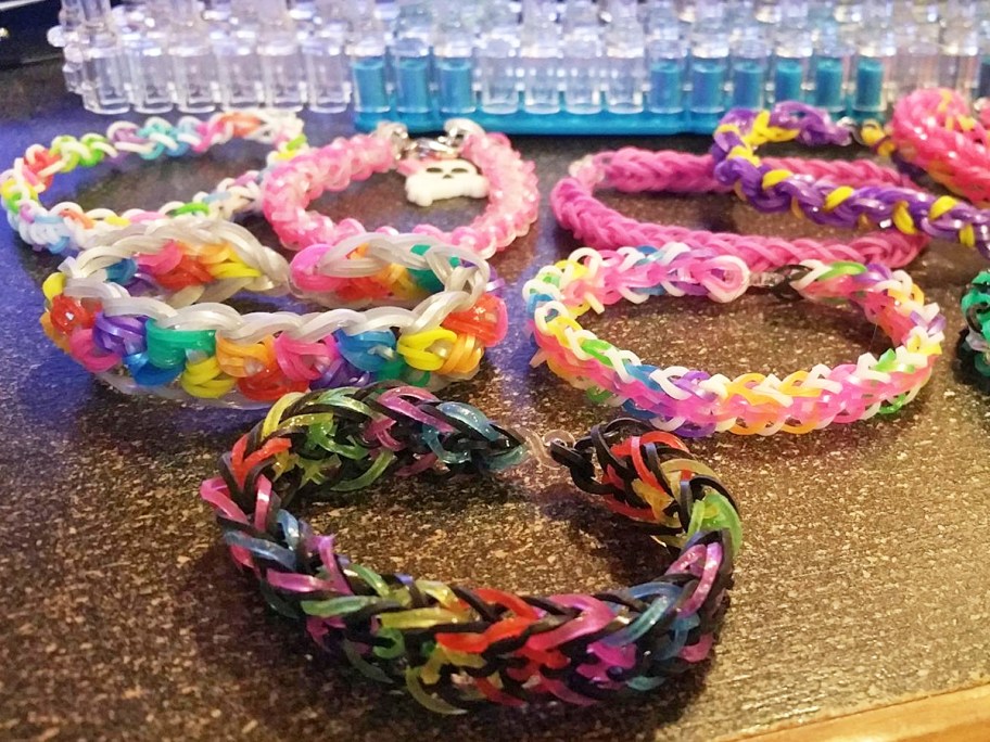various colorful rainbow loom bracelets on table