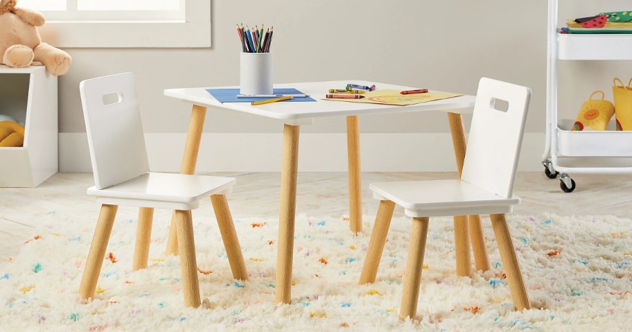 white and wood kid's activity table and chairs in a playroom