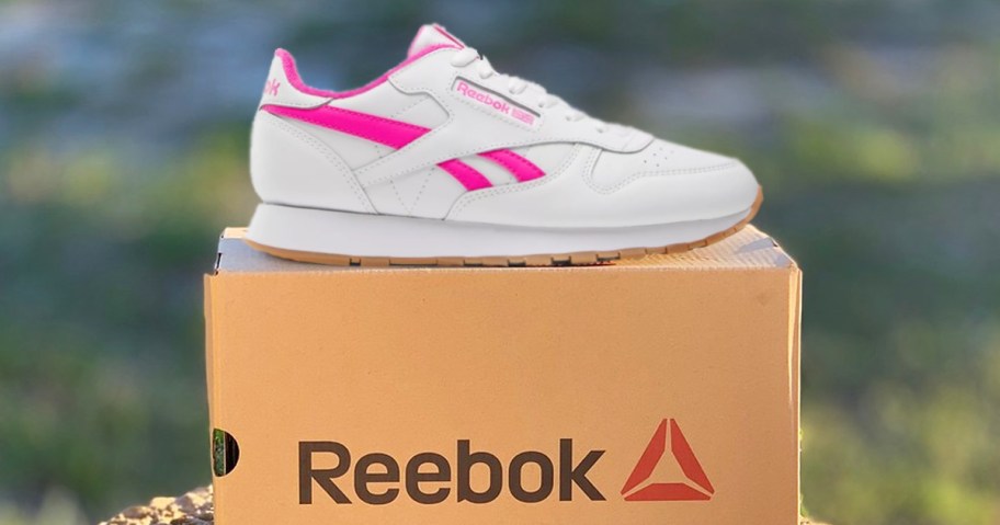 white and pink sneaker on top of a reebok shoe box