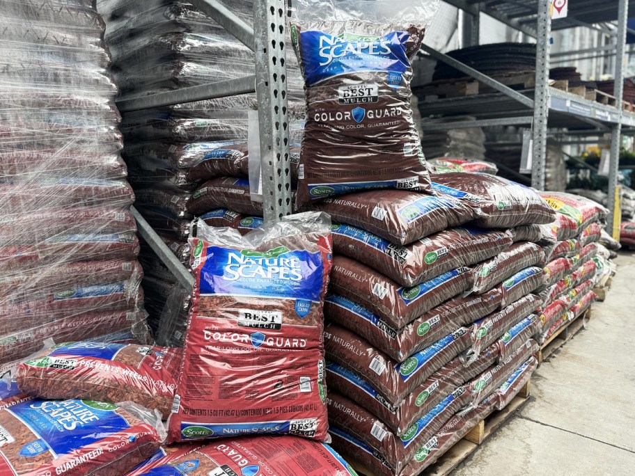 red and brown bags of mulch in garden center of hardware store