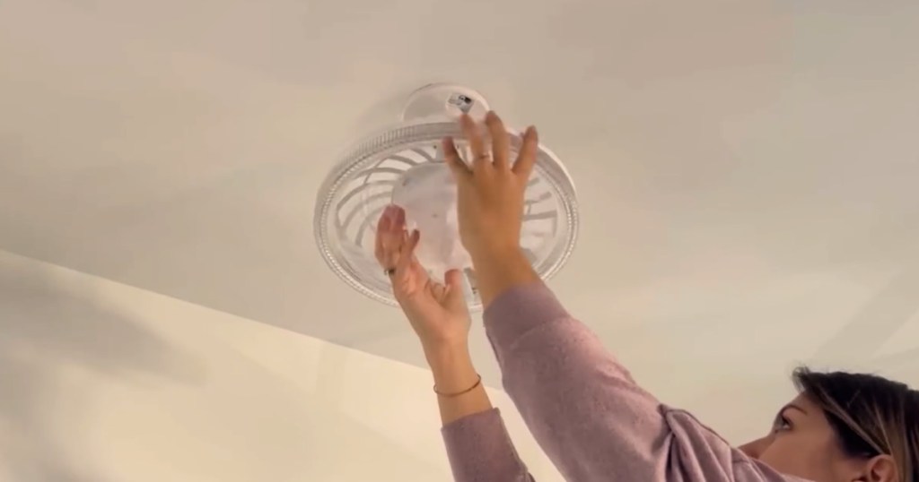 woman installing Socket Ceiling Fan