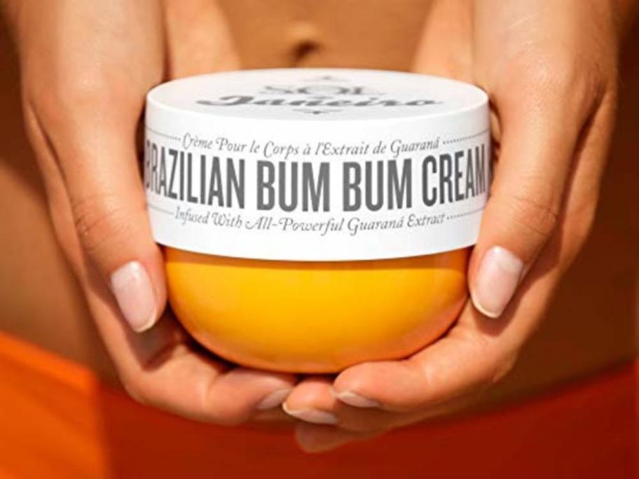 woman holding sol de janeiro brazilian bum bum cream