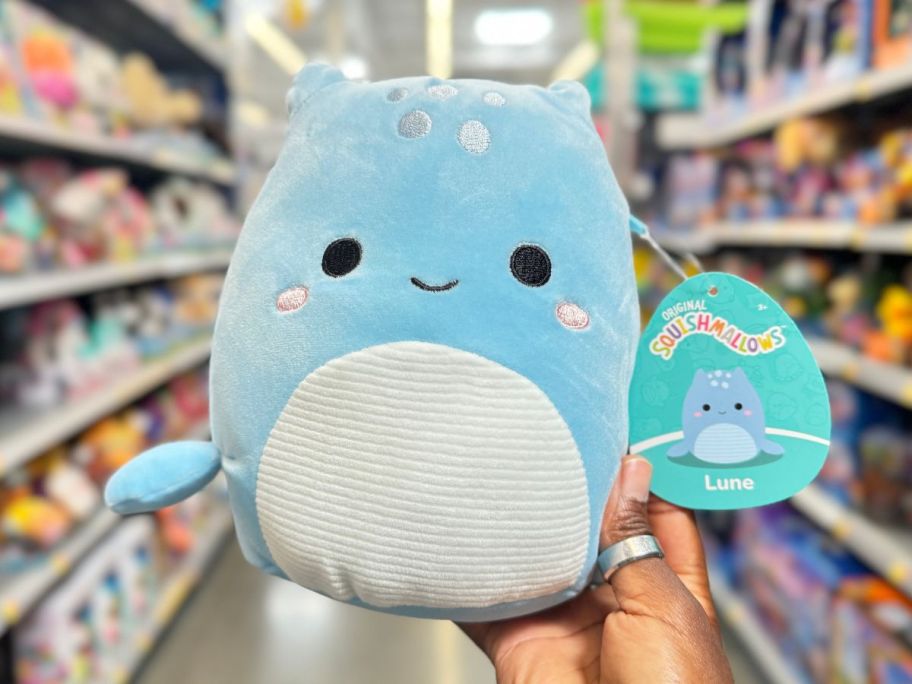 A hand holding a Squishmallows Lune