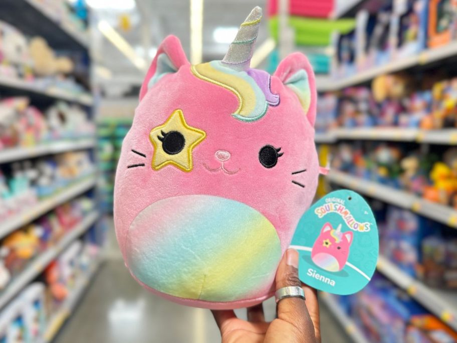 A hand holding a Squishmallows Sienna