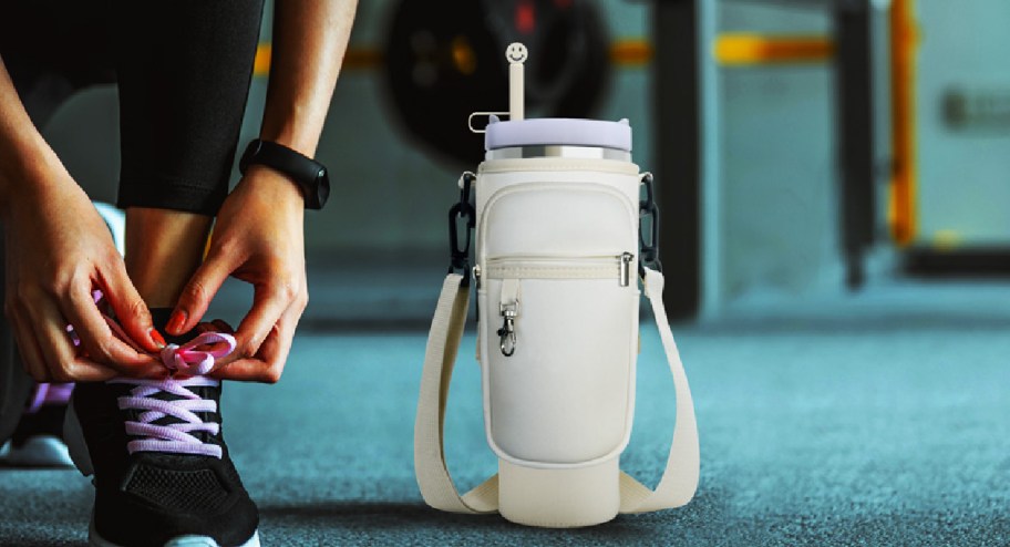 Stanley tumbler carry bag next to someone tying their shoes on the floor