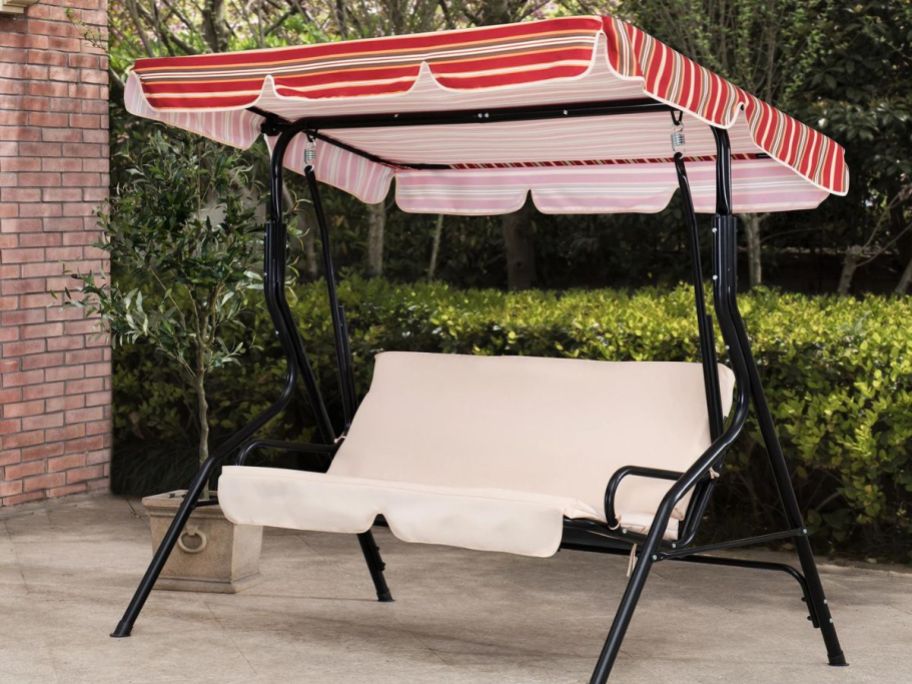 Sunjoy 2-Person Outdoor Swing w/ Beige & Red Striped Adjustable Canopy & Cushions on patio