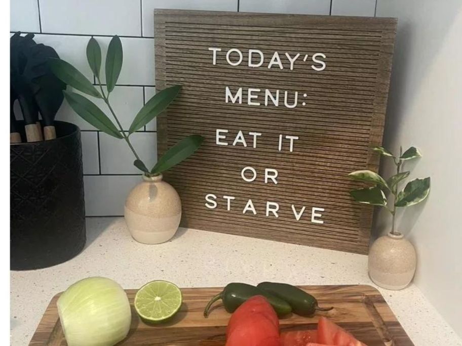 A wooden sign with letters spelling out "Today's menu: eat it or starve." 