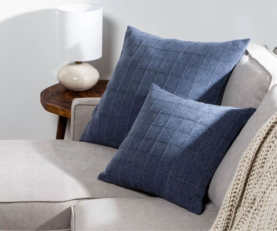 an arrangement of 2 blue throw pillows on a sofa