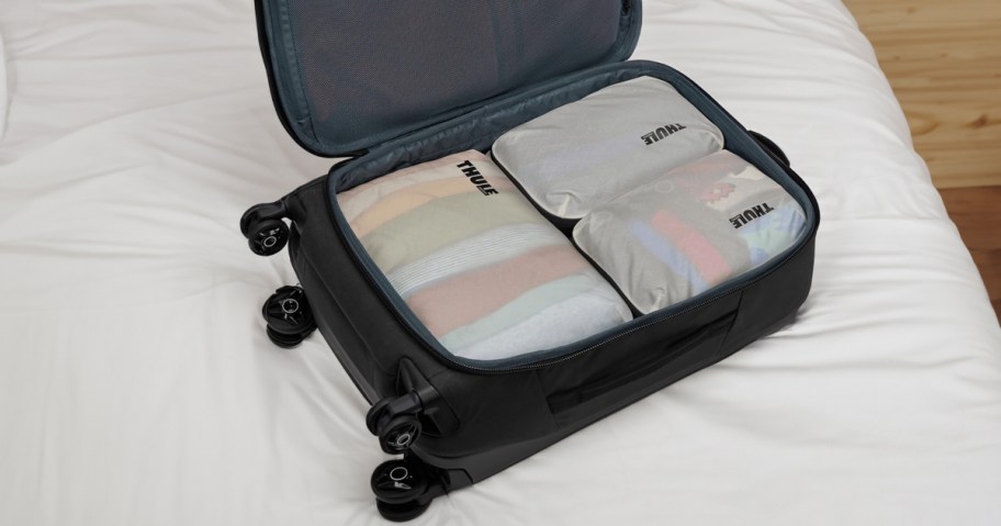 Thule compression set in a suitcase on a bed