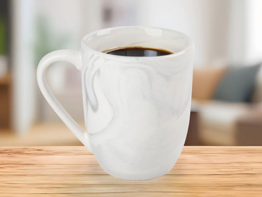 a white and grey marble print coffee mug on a wooden table top