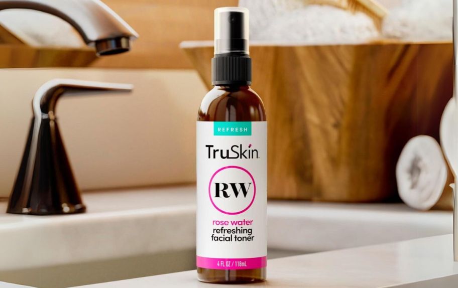 a bottle of truskin rosewater toner spray next to a bathroom sink