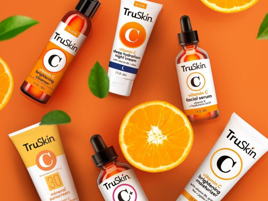 Several different TruSkin Vitamin C Skincare Products next to halves of oranges and green leaves