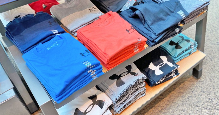 display table full of folded under armour shirts