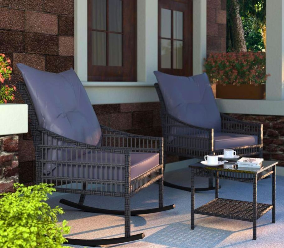 a 3 piece outdoor conversation set in gray wicker with gray cushions on a front porch