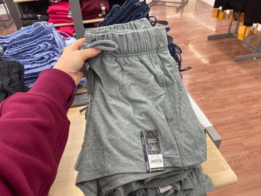 A hand holding a pair of Walmart Athletic Works Shorts
