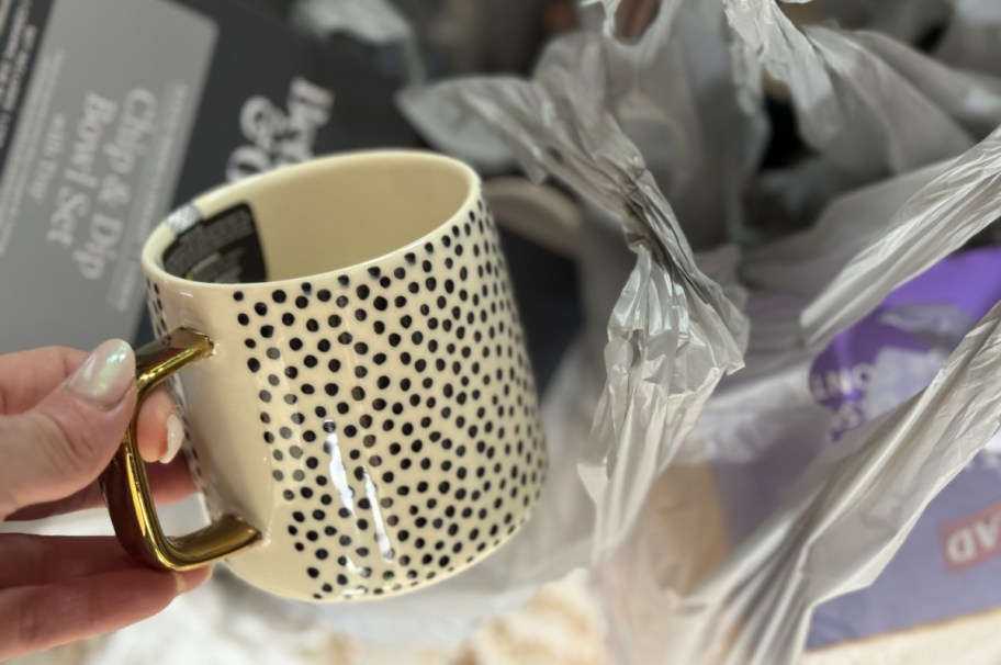 hand holding a walmart mug with a dot pattern